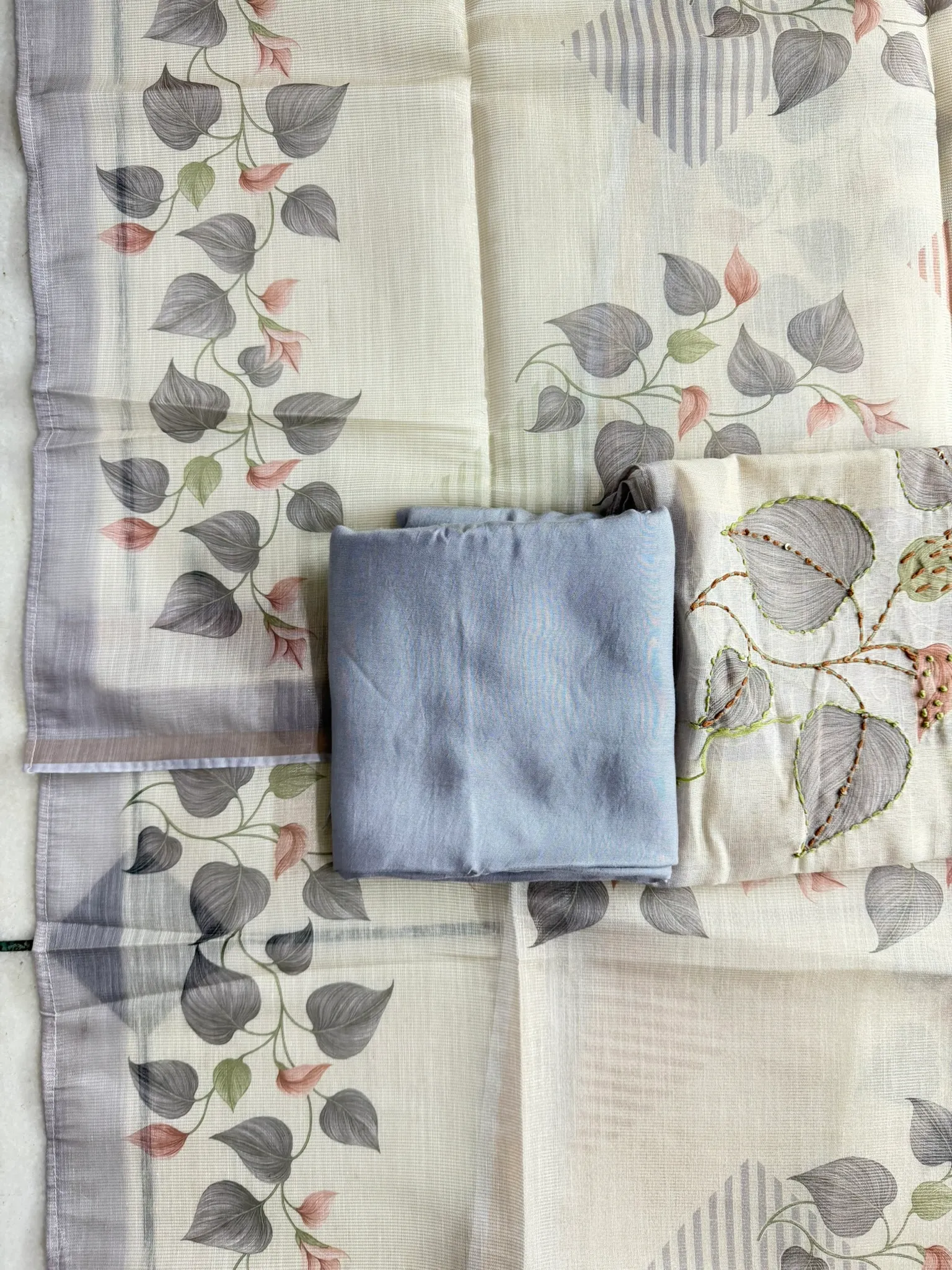 Each printed leaf returned to the embroiderers — green scallop edges, a maroon vein, and a scatter of sequins.