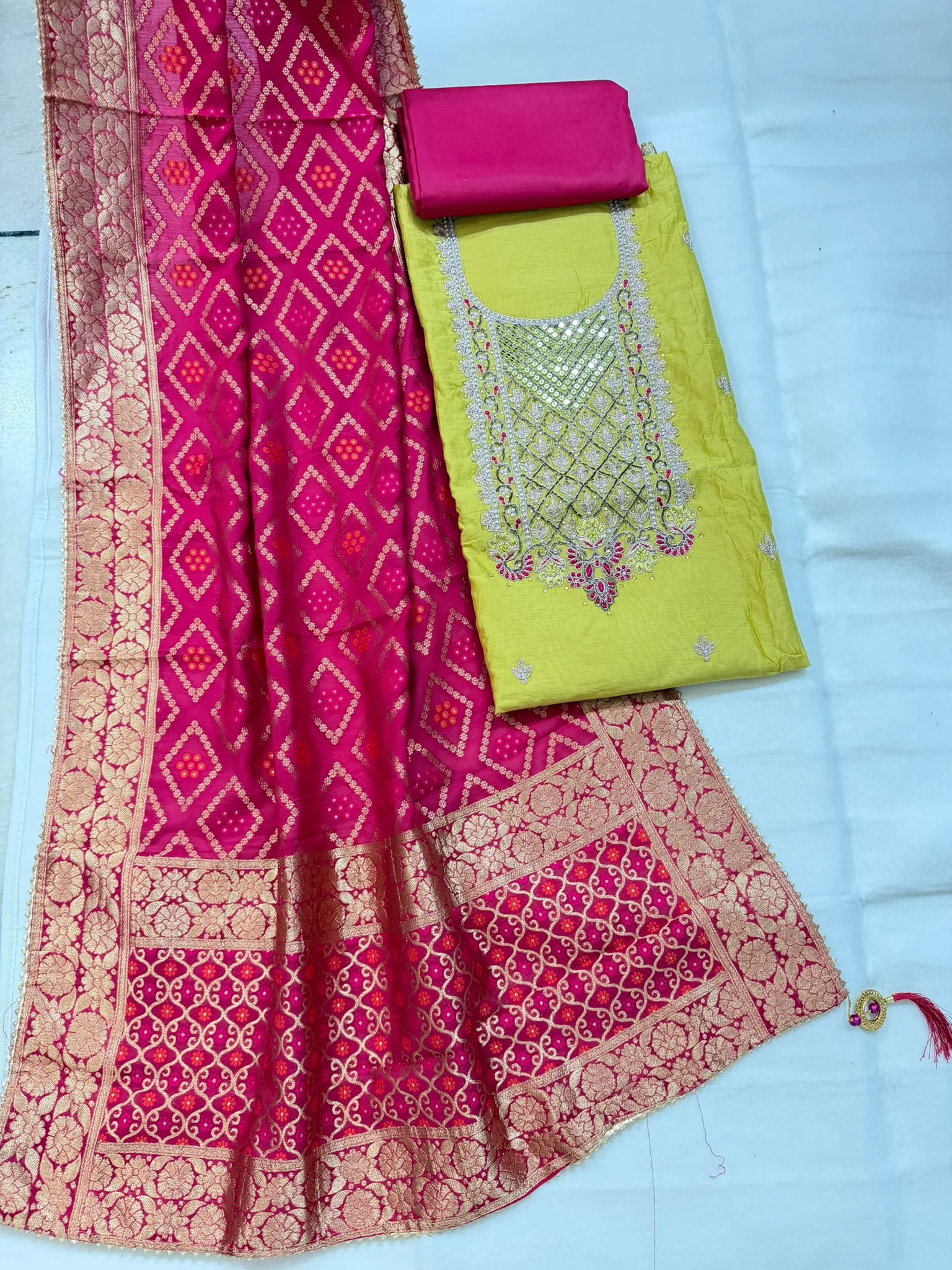 The neckline yoke — pearl, gota and zari worked into a lattice, with stone accents in pink.