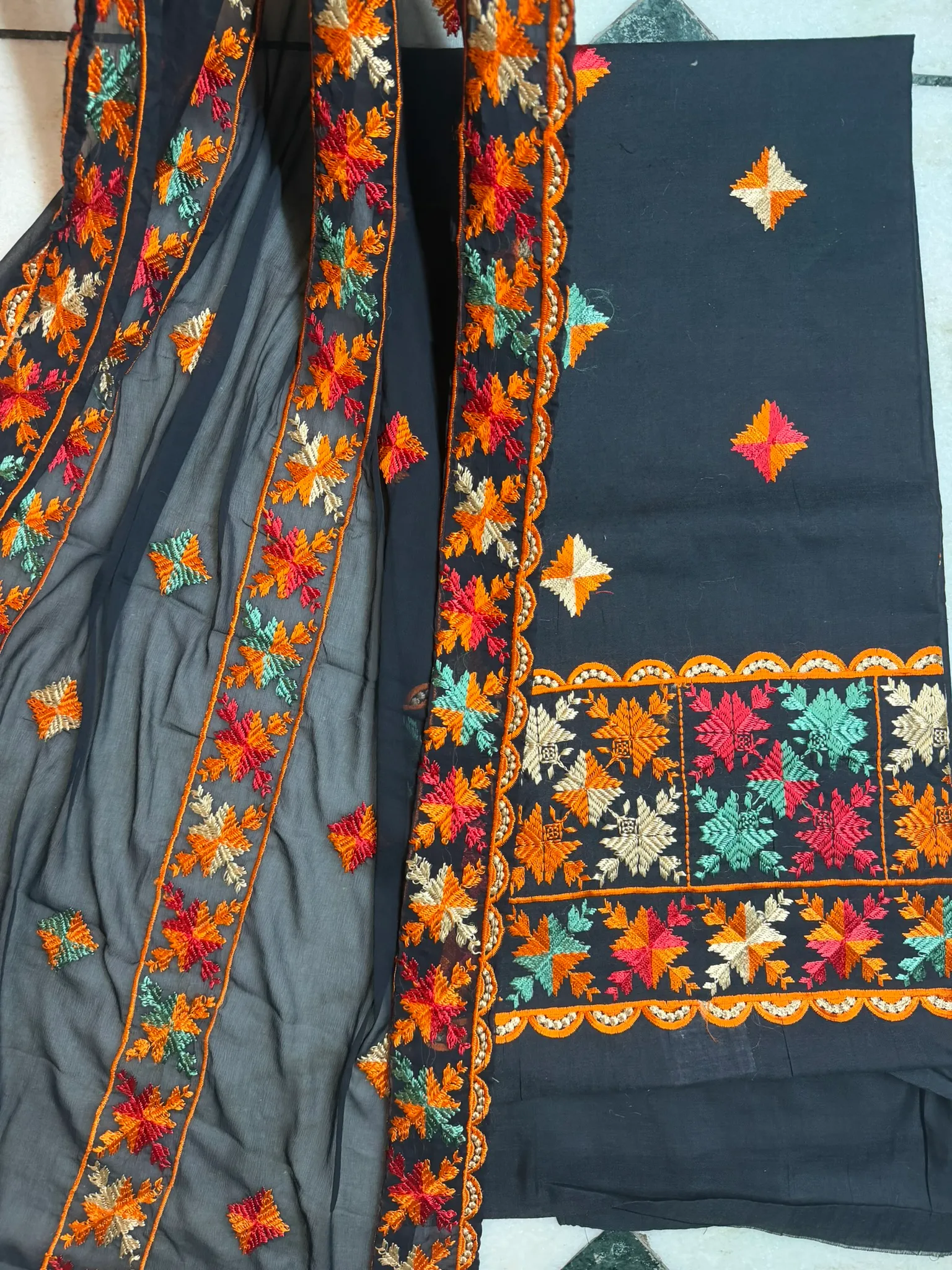 The sheer dupatta carries the same flowers down the length of both borders.